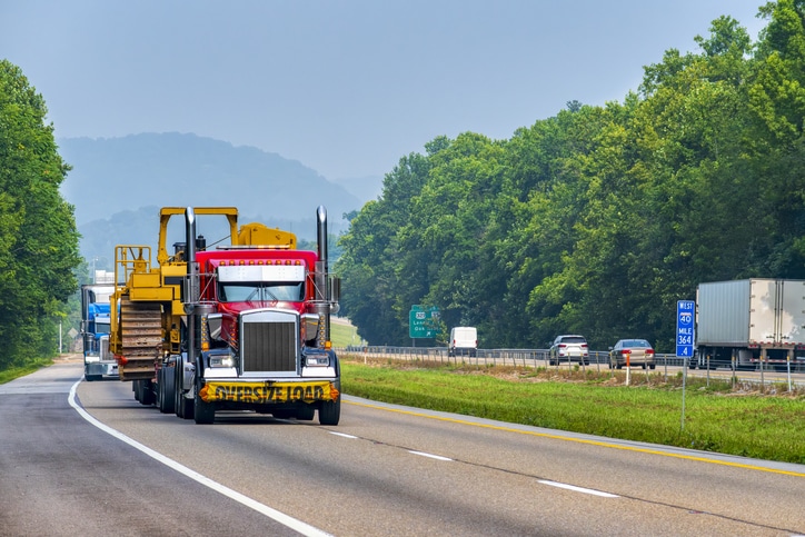 Horizontal shot of heavy machinery being transported on a Tennessee interstate highway.